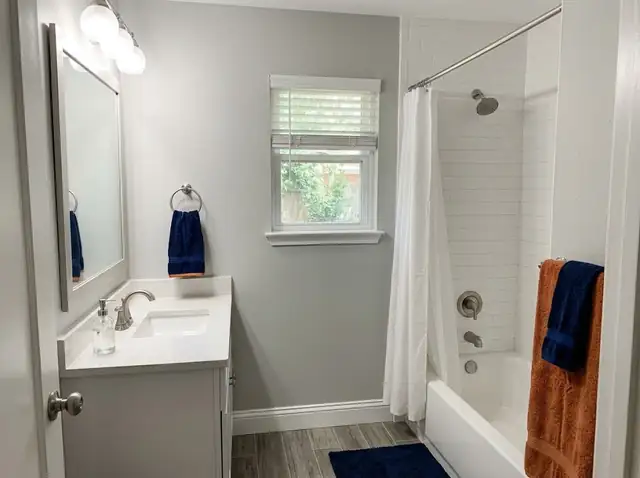 Illustration of a small finished bathroom with a white tub, subway tile and a white vanity