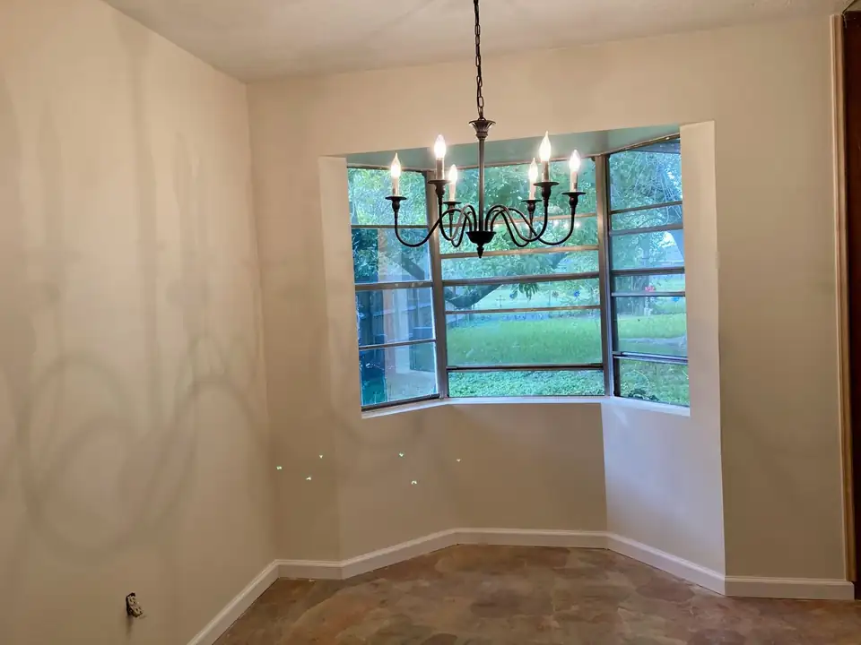 Dining room with a bay window and chandelier, rebuilt after termite damage with new drywall and paint: remodeling in Pasadena, TX by M&J